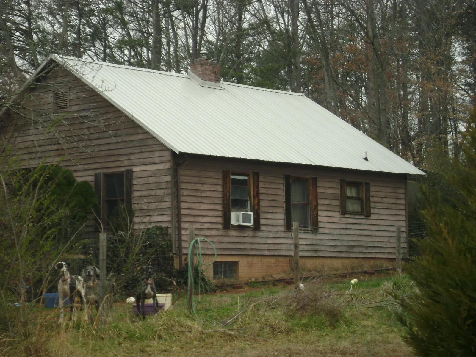 White metal roof on an old wood sided farmhouse, from a Metal Roof Installation job in Oakland